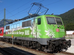 Baureihe 111 der |DBAG| mit n-Wagen im |Bf| @mmw; mit Werbelackierung 'Mit der Bahn in die Berge'