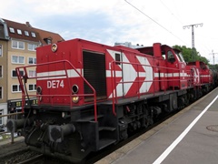 DE 1002 der |HGK| mit Güterzug bei der Durchfahrt im |Bf| @kks;